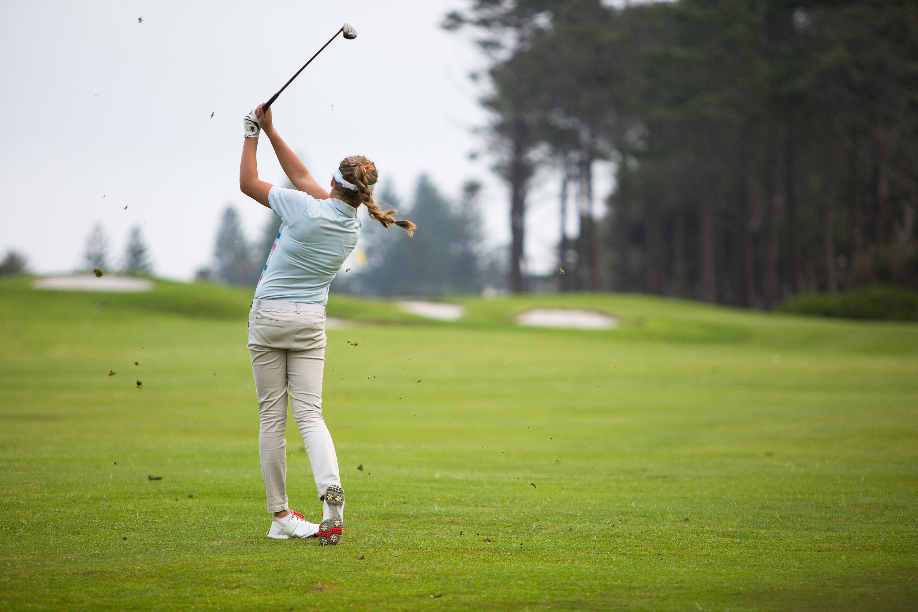 Female golfer executing confident swing
